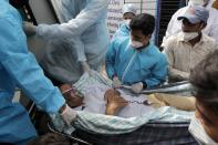 Health workers carry a patient after a fire in Vijay Vallabh COVID-19 hospital at Virar, near Mumbai, India, Friday, April 23, 2021. A fire killed 13 COVID-19 patients in a hospital in western India early Friday as an extreme surge in coronavirus infections leaves the nation short of medical care and oxygen. (AP Photo/Rajanish Kakade)