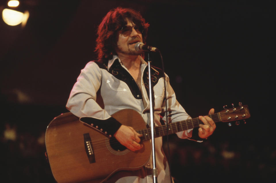 Raymond Froggatt, British singer-songwriter, playing the guitar and singing into a microphone during a live concert performance, circa 1975. (Photo by Mike Prior/Redferns/Getty Images)