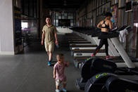 Huang Wensi's husband Deng Peipeng, looks after their son while accompanying her on a training session in a local gym in Lianjiang, Guangdong province, China, July 2, 2018. REUTERS/Yue Wu