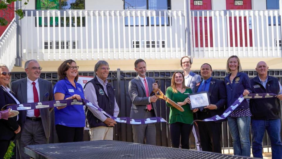 Local leaders hold a ribbon cutting as part of the grand opening of the Paso Homekey housing complex on Oct. 3, 2023. The project, which occupies the former Motel 6 in Paso Robles, offers 28 rooms of emergency shelter space and 60 permanent supportive units of affordable housing.
