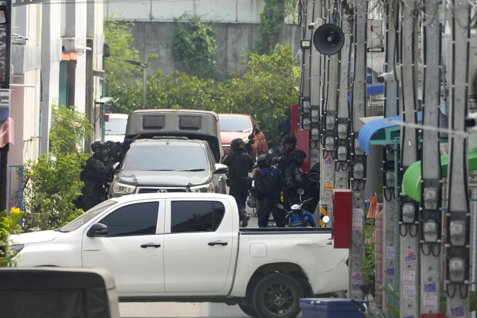 A group of armed commando police are seen outside the home of a senior police officer in Bangkok, Thailand, Wednesday, March 15, 2023. Thai police have arrested a fellow officer who fired multiple gunshots from his home in Bangkok which forced an over 24 hours-long standoff after his colleagues tried to take him to be treated for mental illness. (AP Photo/Sakchai Lalit)