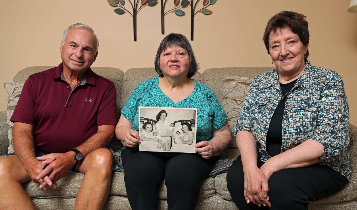 Triplet cousins Richard Leonard Jr., Marie Buehler and Phyllis Antonino sit for a portrait Tuesday with a 1948 photograph taken in the maternity ward of St. Thomas Hospital in Akron.