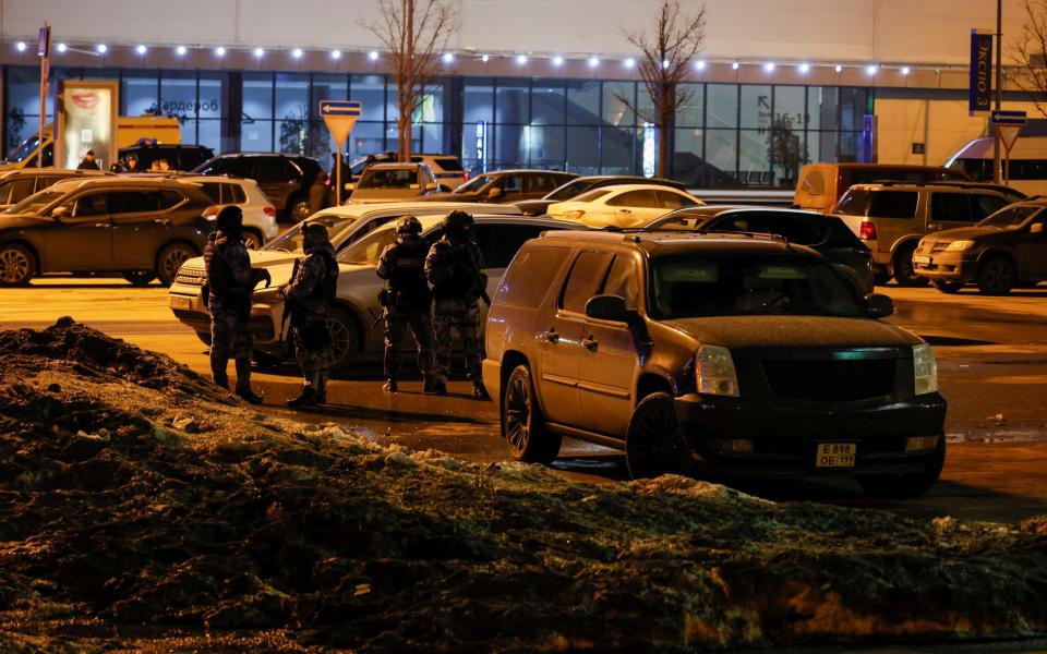 Members of Russian special operations forces stand guard near the burning Crocus City Hall concert venue