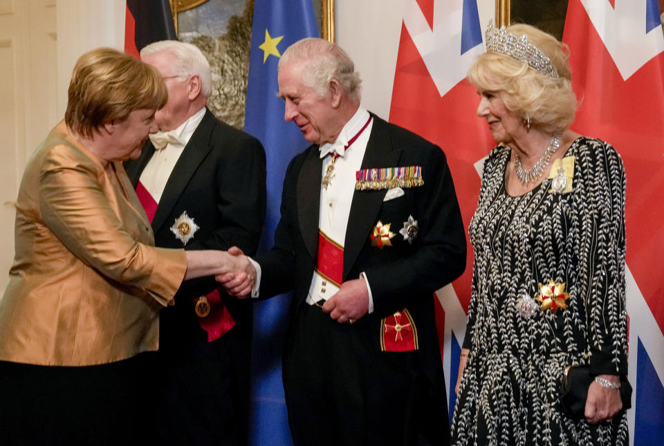 Former German Chancellor Angela Merkel, left, shakes hand with Britain's King Charles III, centre, and Camilla, the Queen Consort, during the State Banquet in Berlin, Wednesday, March 29, 2023. King Charles III arrived Wednesday for a three-day official visit to Germany. (AP Photo/Matthias Schrader, Pool))