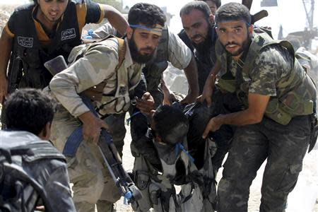 Free Syrian Army fighters carry their fellow fighter after he was wounded on the front line in Aleppo's Sheikh Saeed neighbourhood September 21, 2013. REUTERS/Molhem Barakat