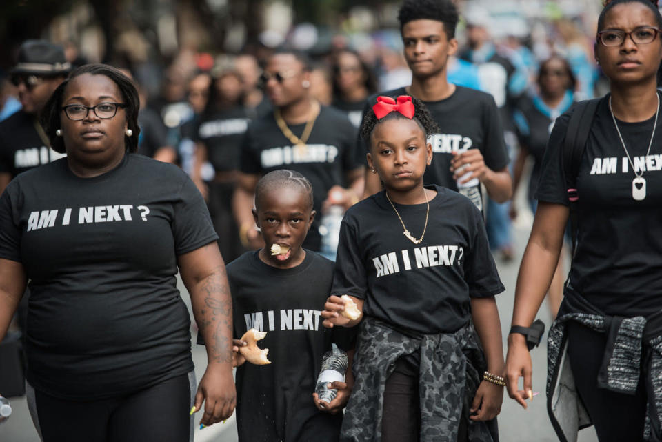 <p>A young boy eats a donut as he walks with demonstrators down a street outside of Bank of America Stadium before an NFL football game between the Charlotte Panthers and the Minnesota Vikings on Sept. 25, 2016 in Charlotte, N.C. (Sean Rayford/Getty Images)</p>