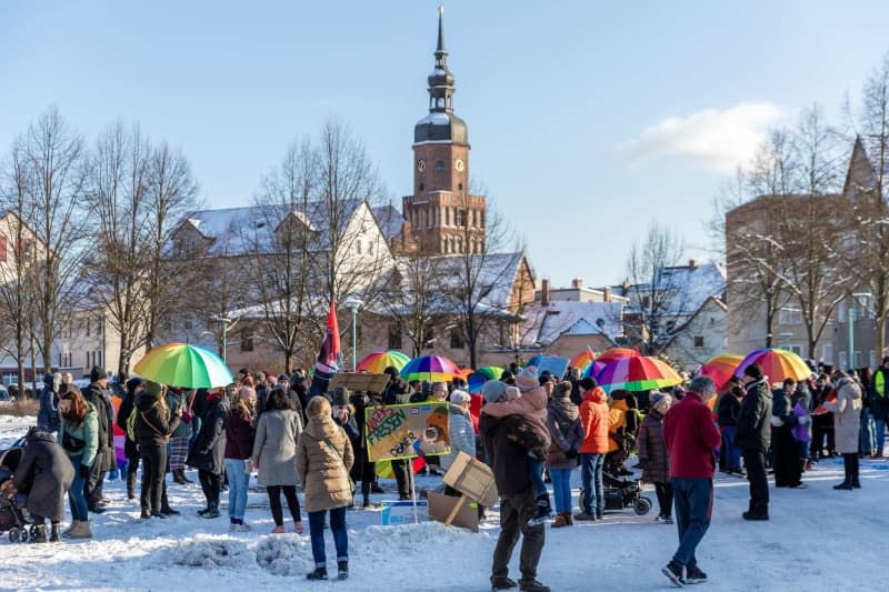 People holding umbrellas in rainbow colors at a demonstration entitled "A colorful future instead of a brown hinterland" against right-wing extremism in Spremberg. Frank Hammerschmidt/dpa