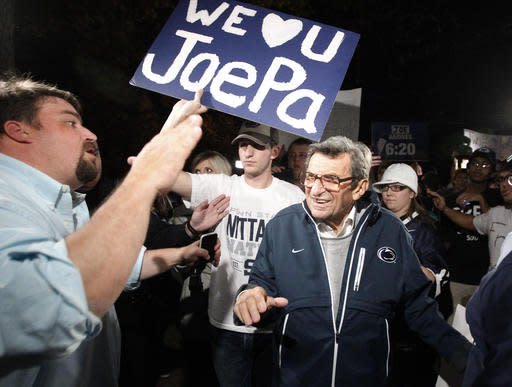 FILE - In this Nov. 8, 2011 file photo, Scott Paterno, left, looks on as students greet his father Penn State football coach Joe Paterno as he arrives at his home in State College, Pa. Scott Paterno said in a tweet sent May 6, 2016 that an allegation made by insurers that a boy told the longtime Penn State football coach in 1976 that he had been molested by former assistant coach Jerry Sandusky is “bunk.” (AP Photo/Matt Rourke, File)