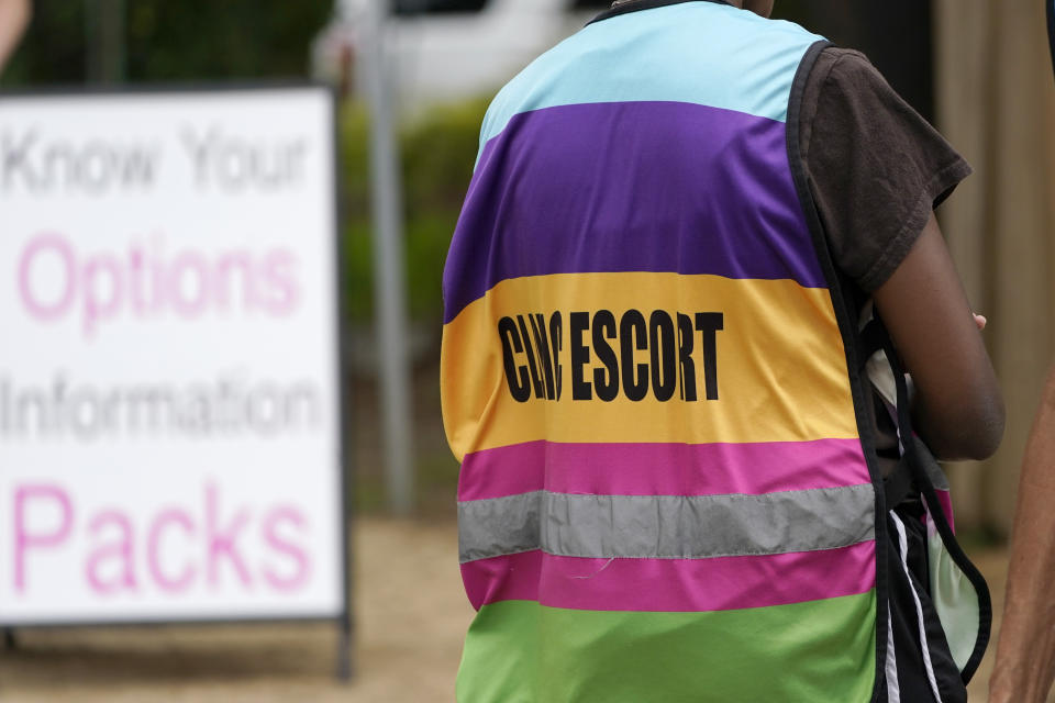 A clinic escort waits in the driveway of the Jackson Womens Health Organization clinic parking lot, to assist any patient entering, Thursday, May 20, 2021, in Jackson, Miss. The clinic is Mississippi's only state licensed abortion facility. On May 17, 2021, the U.S. Supreme Court agreed to take up the dispute over a Mississippi ban on abortions after 15 weeks of pregnancy. The issue is the first test of limits on abortion access to go before the conservative majority high court. Their decision could mean more restrictions, and focuses on the landmark 1973 ruling in Roe v. Wade, which established a woman's right to an abortion. (AP Photo/Rogelio V. Solis)