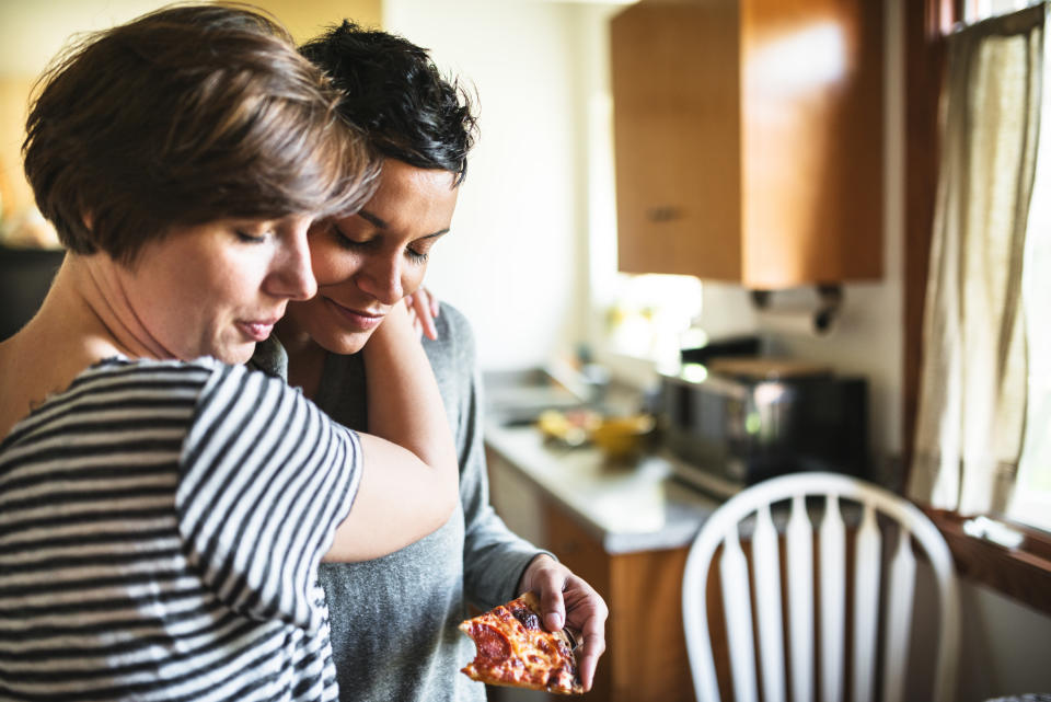 lesbian couple eating the pizza togetherness