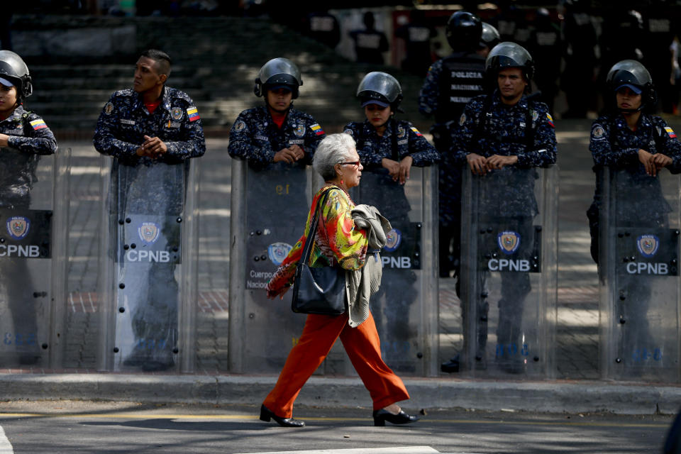 Police stand guard in anticipation of a march called by a coalition of opposition parties and civic groups who are petitioning lawmakers for a law of guarantees that will protect workers who have been victims of political retaliation and unjustified dismissals, in Caracas, Venezuela, Tuesday, March 19, 2019. (AP Photo/Natacha Pisarenko)