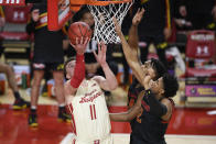 Wisconsin forward Micah Potter (11) goes to the basket against Maryland guard Aaron Wiggins (2) and forward Donta Scott, back, during the first half of an NCAA college basketball game Wednesday, Jan. 27, 2021, in College Park, Md. (AP Photo/Nick Wass)