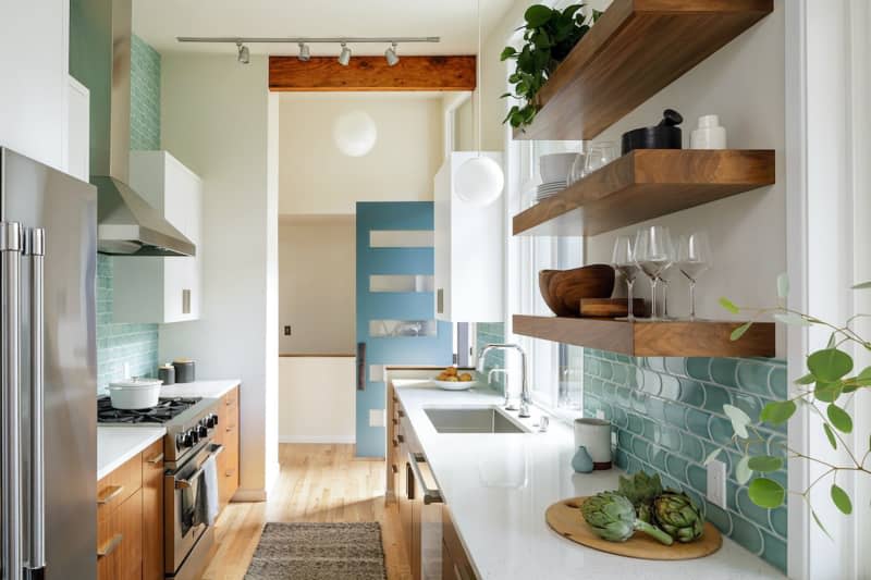 Modern white kitchen with blue and wood accents