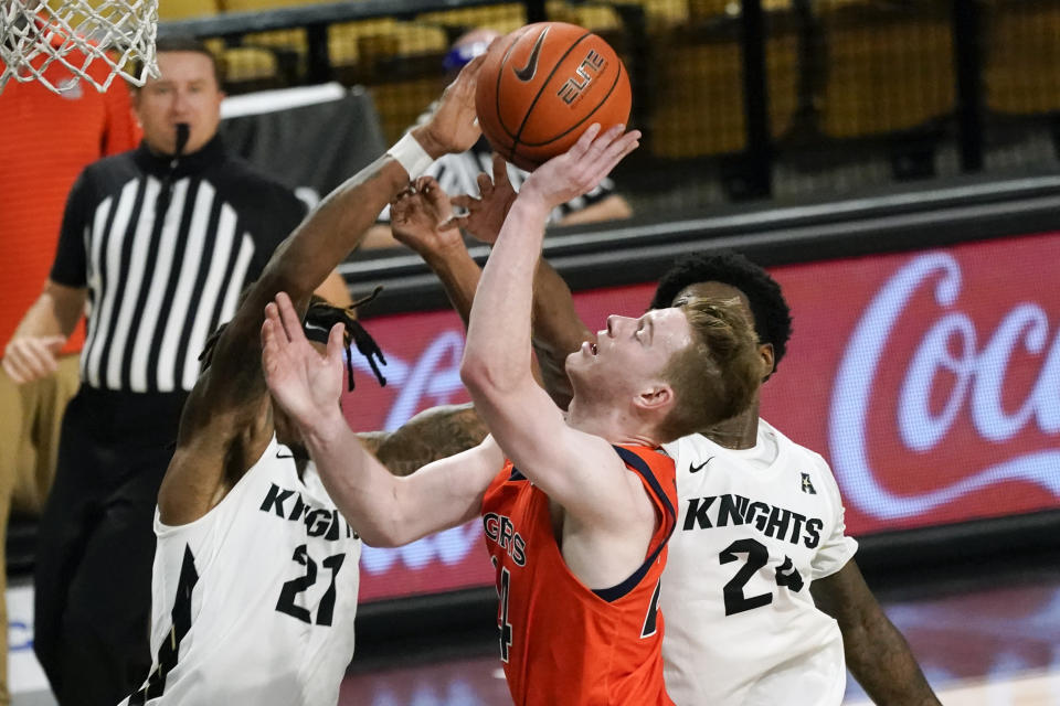 Central Florida forward C.J. Walker (21) blocks a shot-attempt by Auburn guard Justin Powell, center, as Central Florida guard Dre Fuller Jr., right, comes in to help during the second half of an NCAA college basketball game, Monday, Nov. 30, 2020, in Orlando, Fla. (AP Photo/John Raoux)