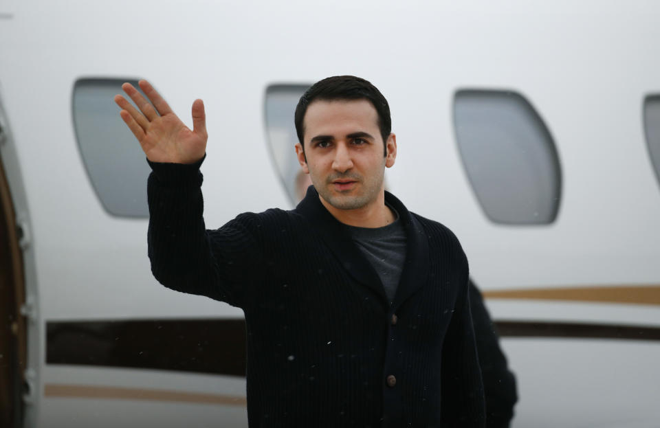 FILE - In this Jan. 21, 2016, file photo, Amir Hekmati waves after arriving on a private flight at Bishop International Airport in Flint, Mich. A former U.S. Marine freed from Iranian custody five years ago is in court with the American government over whether he can collect a multimillion-dollar payment from a special fund for victims of international terrorism. Newly filed court documents show that the FBI opened an investigation into Hekmati, on suspicions that he went to Iran to sell classified information to the regime. He vigorously disputes those allegations. (AP Photo/Paul Sancya, File)