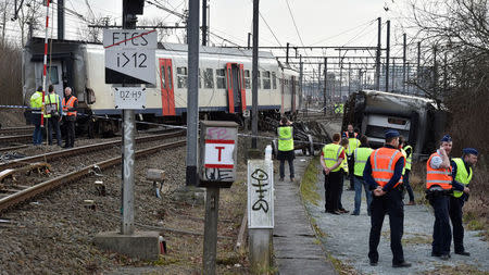 Rescuers and police officers stand next to the wreckage of a passenger train after it derailed in Kessel-Lo near Leuven, Belgium February 18, 2017. REUTERS/Eric Vidal