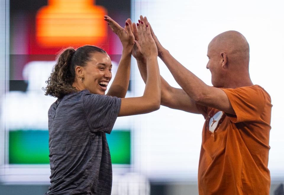 Texas volleyball star Madisen Skinner and coach Jerritt Elliott celebrate throwing out ceremonial first pitches before a Texas baseball game against Texas A&M on March 5. If the softball team can win the Women's College World Series, Texas will become the second school to win NCAA volleyball and softball titles in the same school year.