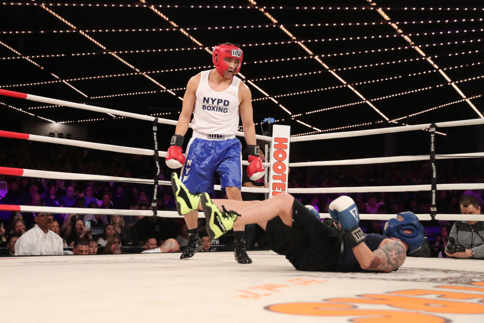 <p>Tom Keung (red) knocks down Mike Almonte (blue) in the Brooklyn Lieutenants Match during the NYPD Boxing Championships at the Hulu Theater at Madison Square Garden on March 15, 2018. (Gordon Donovan/Yahoo News) </p>