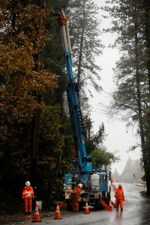 PG&E employees work on power lines to repair damage caused by the Camp Fire in Paradise, California, U.S. November 21, 2018. REUTERS/Elijah Nouvelage