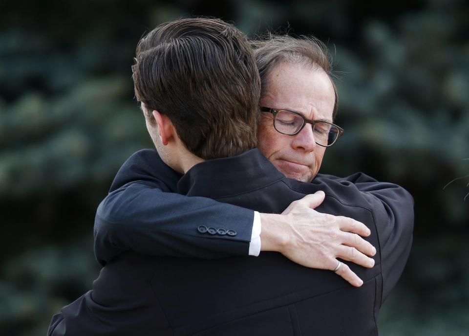 Men hug after the funeral of Jordan Segura in Calgary, Alberta April 21, 2014. Matthew de Grood has been charged with killing Segura and four of his friends at a house party last week in Calgary's worst mass murder in the history of the city, according to local media reports. REUTERS/Todd Korol (CANADA - Tags: CRIME LAW OBITUARY)