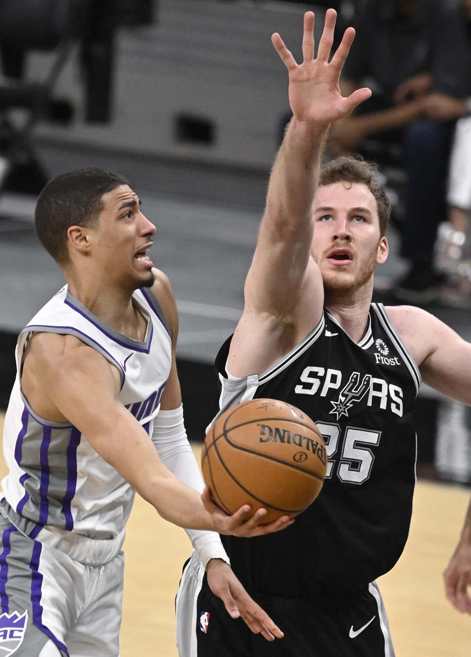 Sacramento Kings' Tyrese Haliburton, left, attempts to shoot against San Antonio Spurs' Jakob Poeltl during the second half of an NBA basketball game Wednesday, March 31, 2021, in San Antonio. (AP Photo/Darren Abate)