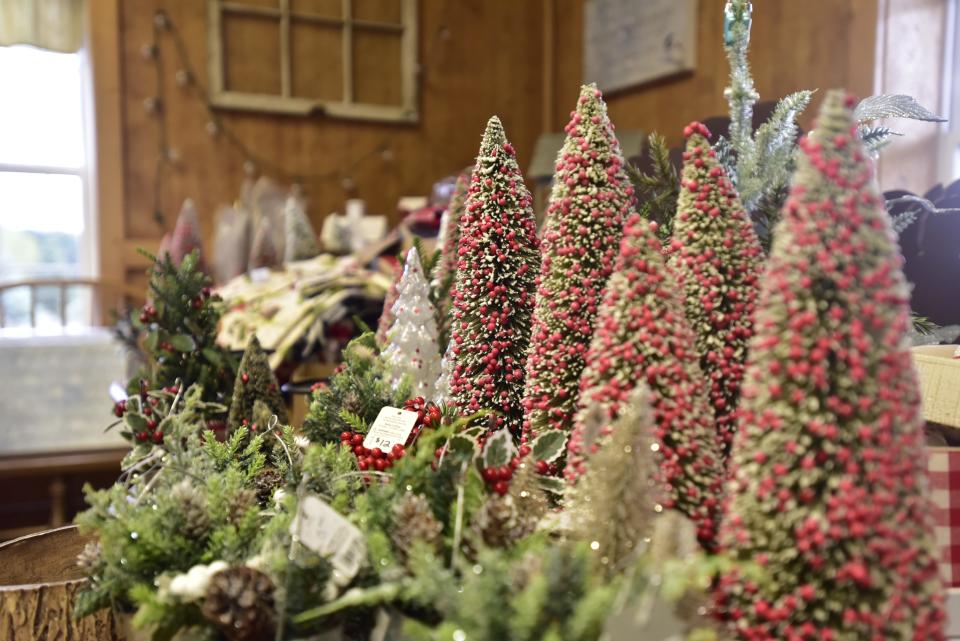 Small Christmas tree decorations at Country Christmas Tree Farm located at 8122 Bricker Road in Greenwood Township Monday, Nov. 14, 2022. The farm’s country store sells wreathes, Christmas decorations and craft supplies. In addition to the country store and trees, customers can enjoy wagon rides and hot chocolate.