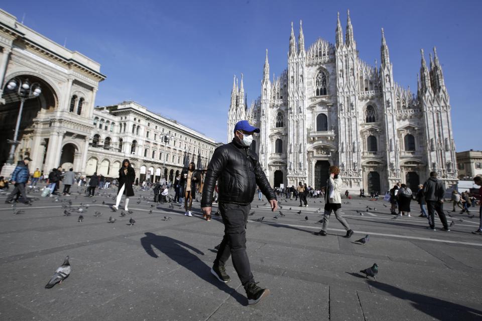 A man wearing a sanitary mask walks past the Duomo gothic cathedral in Milan, Italy, Monday, Feb. 24, 2020. Italy has been scrambling to check the spread of Europe's first major outbreak of the new viral disease amid rapidly rising numbers of infections and calling off the popular Venice Carnival, scrapping major league soccer matches in the stricken area and shuttering theaters, including Milan's legendary La Scala. (AP Photo/Luca Bruno)