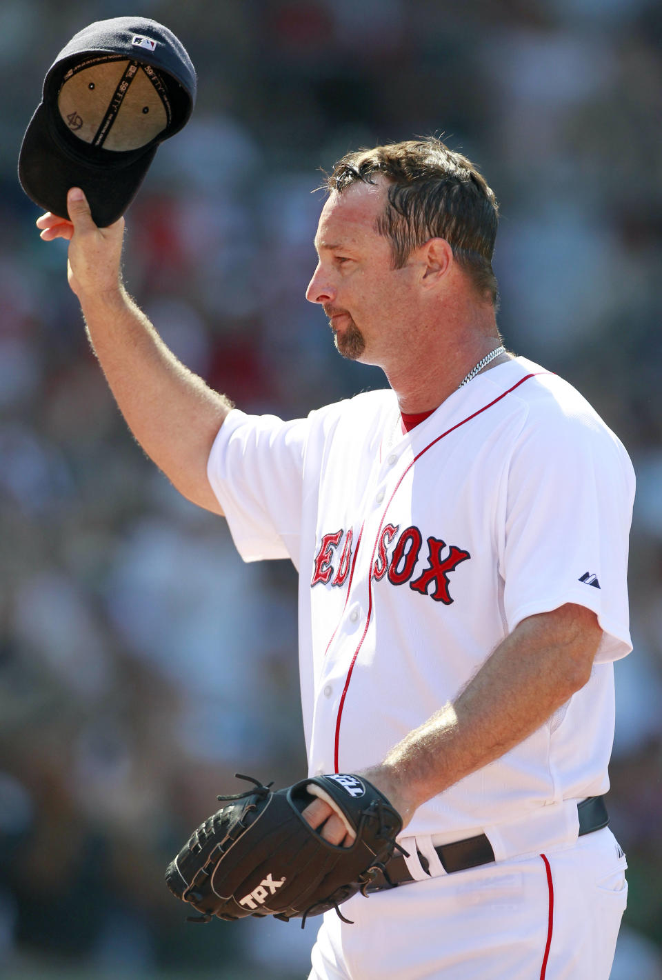 FILE - Boston Red Sox's Tim Wakefield tips his cap as he comes off the field in the sixth inning of a baseball game against the Seattle Mariners in Boston, July 24, 2011. Wakefield, the knuckleballing workhorse of the Red Sox pitching staff who bounced back after giving up a season-ending home run to the Yankees in the 2003 playoffs to help Boston win its curse-busting World Series title the following year, has died. He was 57. The Red Sox announced his death in a statement Sunday, Oct. 1 2023, (AP Photo/Michael Dwyer, file)