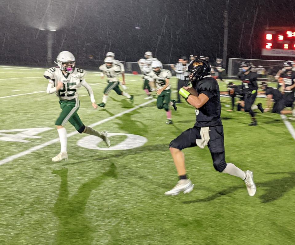 Gardner High quarterback Ayden Sparrow finds running room along the Wildcats' sideline as Bartlett's Caiden Steeves (25) pursues him during a game at Watkins Field in Gardner.