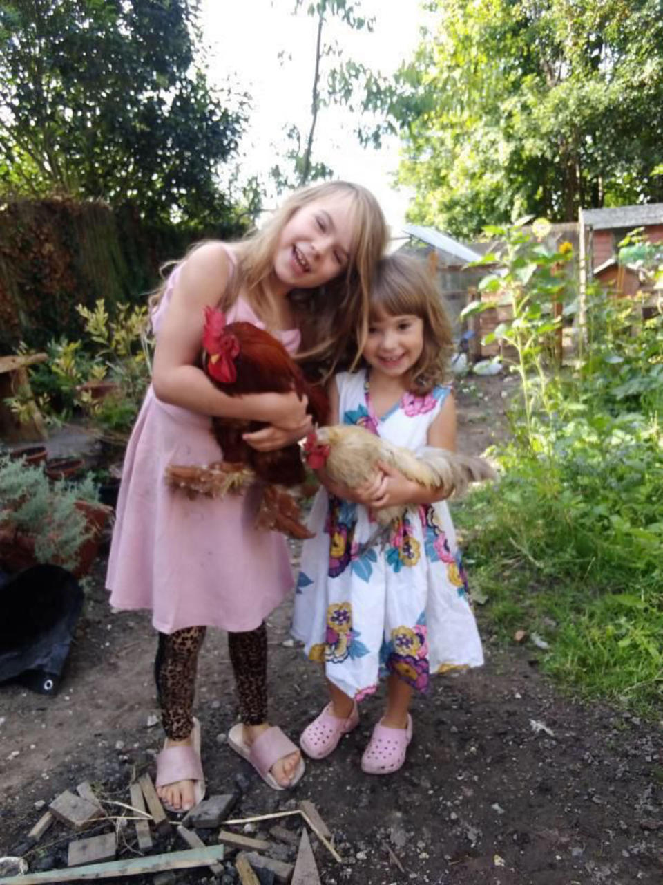 Pictured L-R Ostara and Kai looking after the family chickens. (Caters)