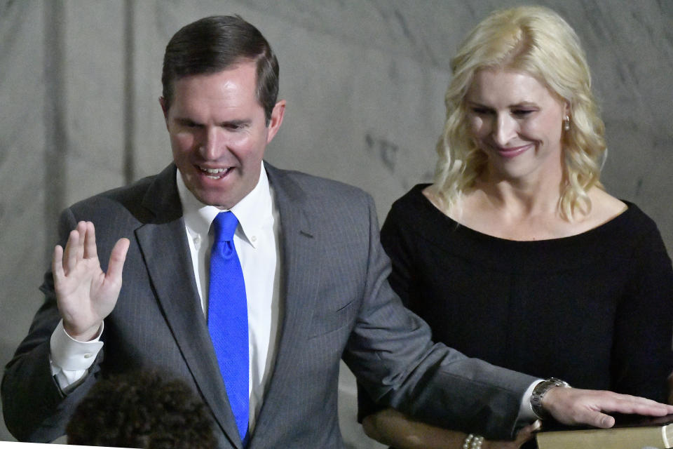 As his wife, Britainy Beshear, holds the Bible, Kentucky Gov. Andy Beshear takes the oath of office from Kentucky Court of Appeals Judge Pamela Goodwine during the 62nd inauguration of Governor in Frankfort, Ky., early Tuesday, Dec. 12, 2023. (AP Photo/Timothy D. Easley)