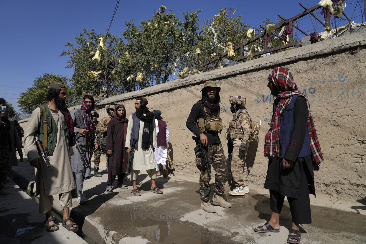 Taliban fighters stand guard in front of an education center that was attacked by a suicide bomber, in Kabul, Afghanistan, Friday, Sept. 30, 2022. A Taliban spokesman says a suicide bomber has killed several people and wounded others at an education center in a Shiite area of the Afghan capital. The bomber hit while hundreds of teenage students inside were taking practice entrance exams for university, a witness says. (AP Photo/Ebrahim Noroozi)