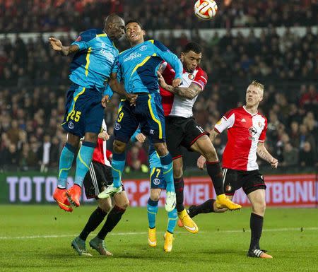 Stephane Mbia of Sevilla and Carlos Bacca of Sevilla fight for the ball with Colin Kazim Richards (2nd R) of Feyenoord during their Europa League soccer match in Rotterdam November 27, 2014. REUTERS/Michael Kooren