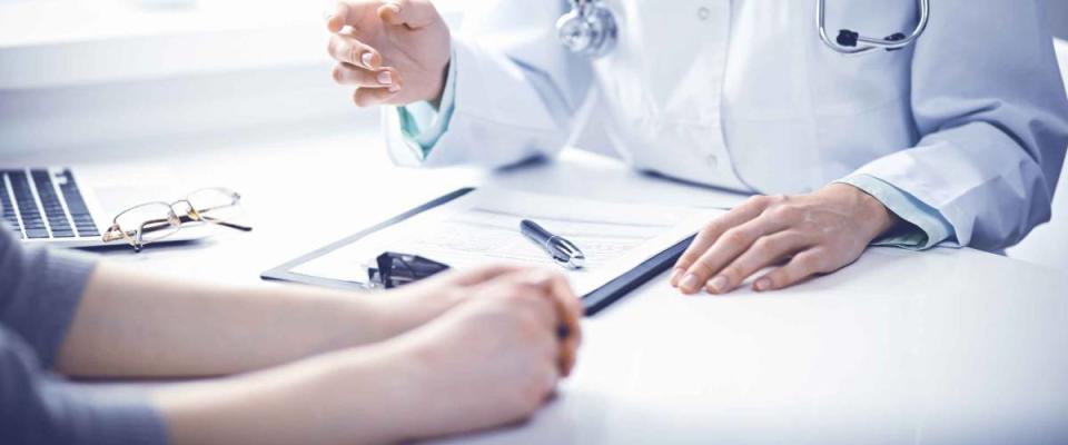 Close up of doctor going over forms with patient across the table from them.