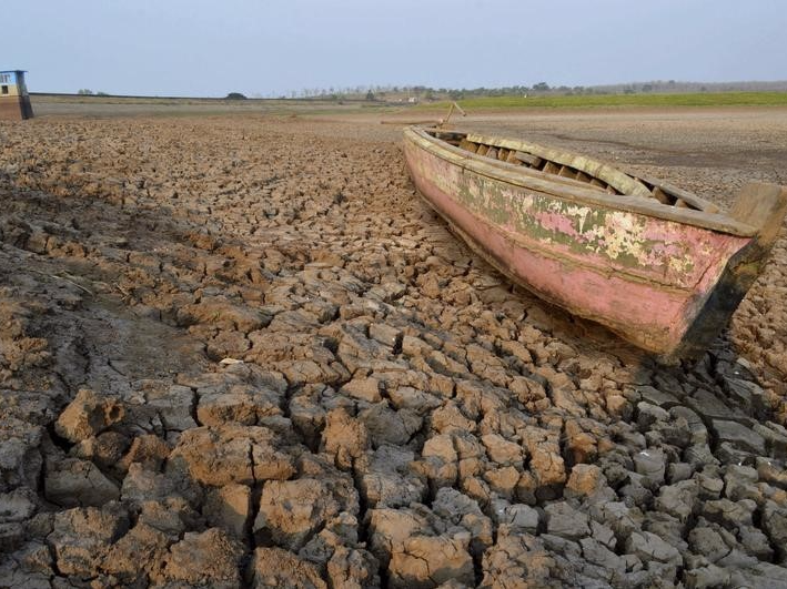A wooden boat is seen stranded on the dry cracked riverbed of the Dawuhan Dam during drought season in Madiun, Indonesia's East Java province, October 5, 2015 in this picture taken by Antara Foto. REUTERS/Siswowidodo/Antara Foto 