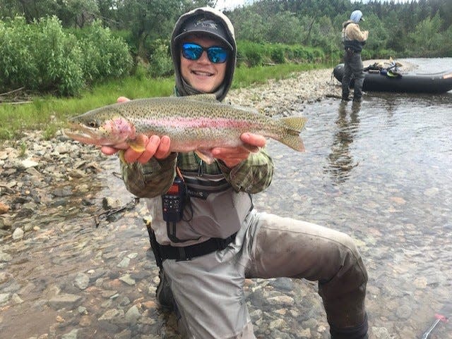 A nice rainbow trout displaying the bright, almost cutthroat colors of Copper River fish is released by Newhalen Lodge guide Evan Hammans in Alaska earlier this month.