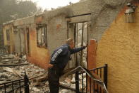 <p>Courtenay Jenvey inspects the remains of his neighbour’s home Saturday, Nov. 10, 2018, in Paradise, Calif. Jenvey was able to save his house during the fire.<br>(Photo from John Locher, AP) </p>