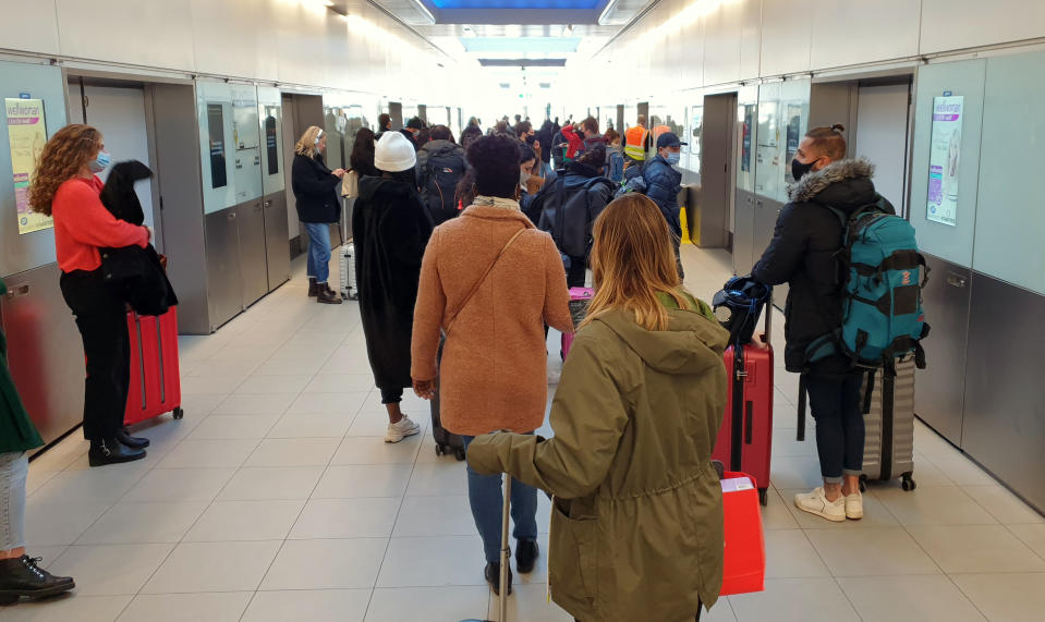 Numerosas personas esperan en la cola para acceder al tren que lleva al aeropuerto de Gatwick. Muchos vuelos se han visto cancelados por la nueva cepa. (Photo by Gareth Fuller/PA Images via Getty Images)