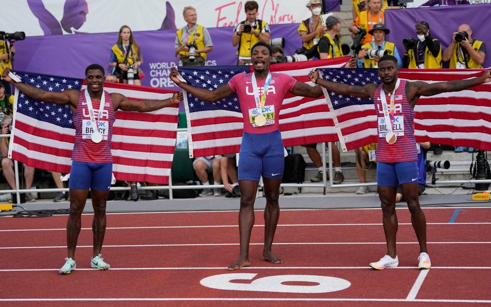 Fred Kerley stands in-between silver medallist Marvin Bracy, left, and bronze medallist Trayvon Bromell - AP