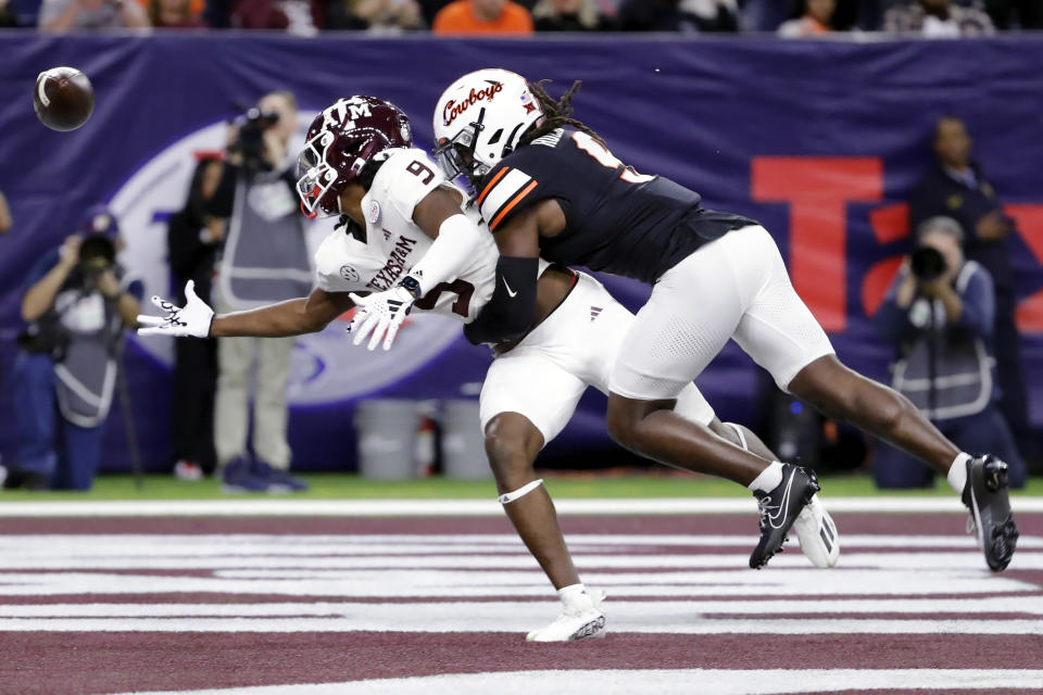 Texas A&M wide receiver Jahdae Walker, left, can't make a reception in the end zone as Oklahoma State safety Trey Rucker defends during the first half of the Texas Bowl NCAA college football game Wednesday, Dec. 27, 2023, in Houston. (AP Photo/Michael Wyke)