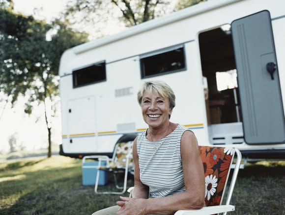 Smiling woman sitting outside her motor home