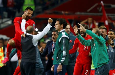 Turkey's coach Fatih Terim (2L) celebrates with Yasin Oztekin and others as his team defeated Iceland during their Euro 2016 Group A qualification soccer match in Konya, Turkey, October 13, 2015. REUTERS/Umit Bektas