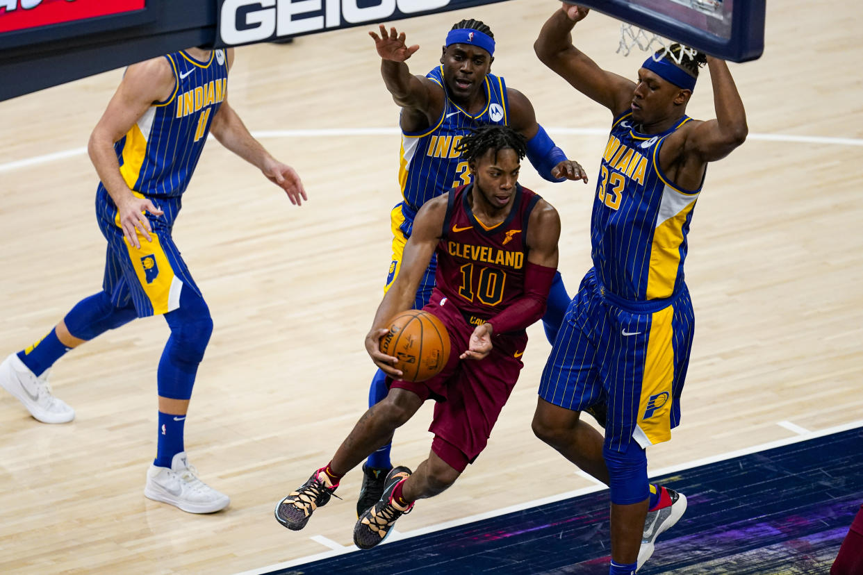 Cleveland Cavaliers guard Darius Garland (10) makes a pass around Indiana Pacers forward Myles Turner (33) during the second half of an NBA basketball game in Indianapolis, Thursday, Dec. 31, 2020. (AP Photo/Michael Conroy)