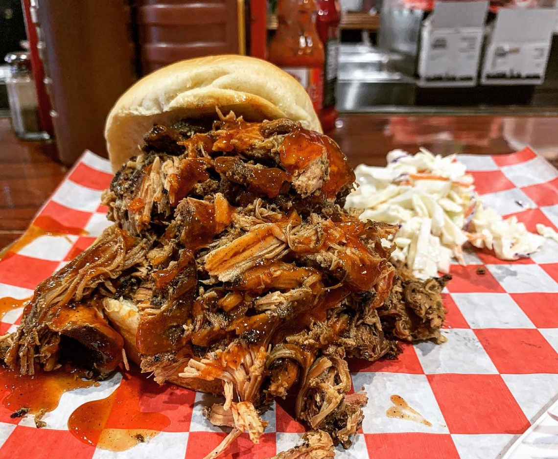 A pulled chicken sandwich busts straight out of its bun at Smokin' This and That Barbecue, in Florence.