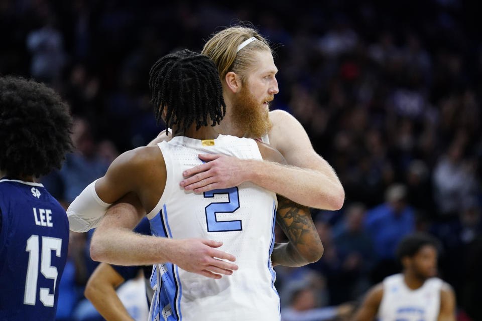 North Carolina's Brady Manek, right, and Caleb Love embrace during the second half of a college basketball game against St. Peter's in the Elite 8 round of the NCAA tournament, Sunday, March 27, 2022, in Philadelphia. (AP Photo/Matt Rourke)