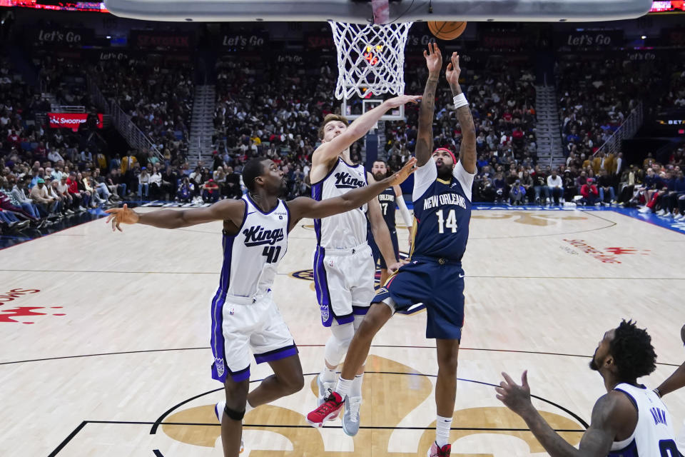 New Orleans Pelicans forward Brandon Ingram (14) shoots against Sacramento Kings forward Trey Lyles (41) and forward Domantas Sabonis (10) in the second half of an NBA basketball game in New Orleans, Wednesday, Nov. 22, 2023. The Pelicans won 117-112. (AP Photo/Gerald Herbert)