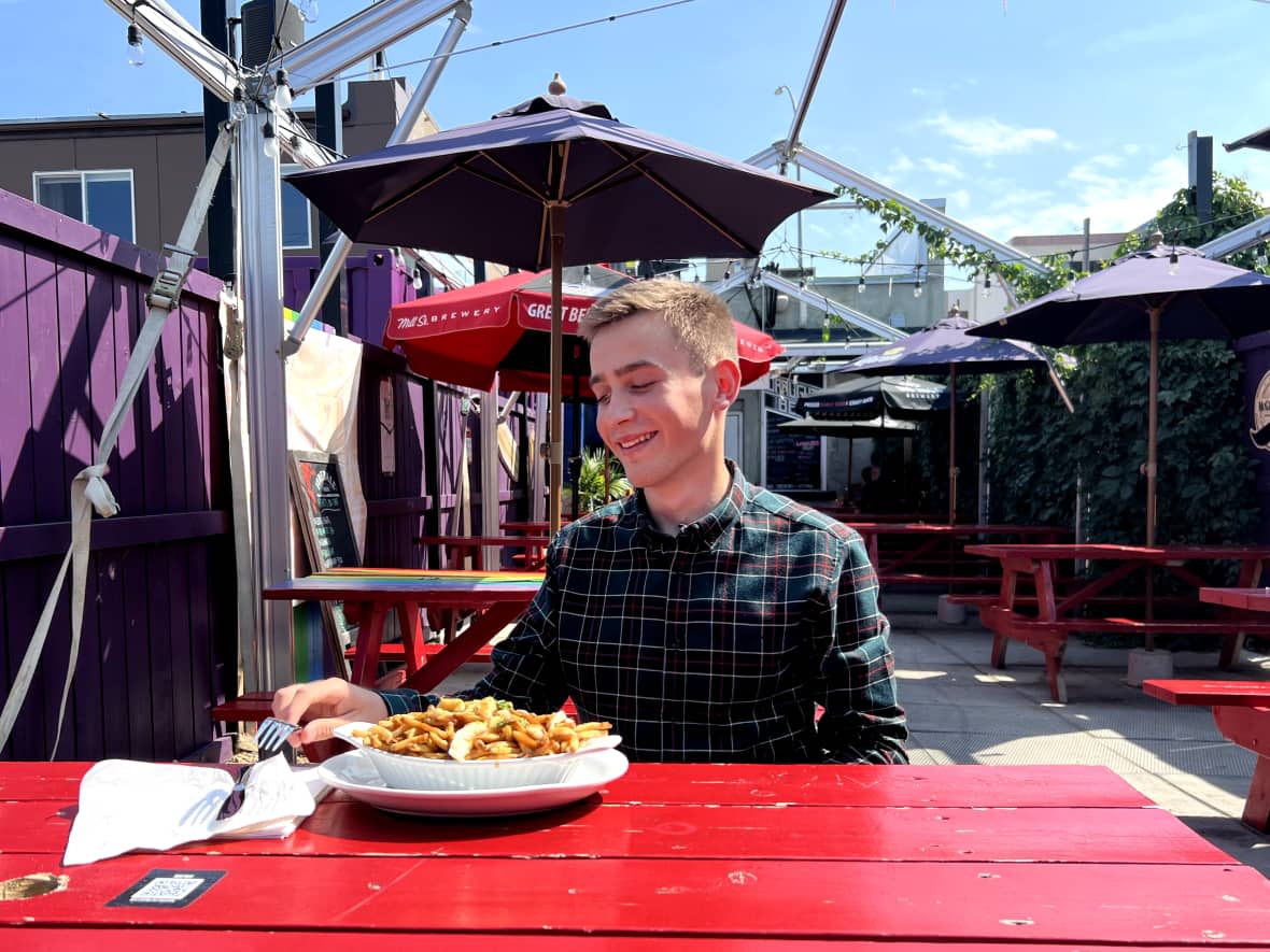 Andrian Maknachov, 19, has blown up on TikTok trying traditional Canadian foods and activities. Trying poutine was one of his top suggestions from followers.  (Adam Bent/CBC - image credit)