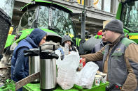 Farmers share a breakfast in the center of Brussels, Belgium, Wednesday, Jan. 31, 2024 ahead of a blockade Thursday. Farmers blocked more traffic arteries across Belgium on Wednesday as they sought to disrupt trade at major ports in a continued push for concessions to get better prices for their produce and less bureaucracy to do their work. The rallies, now in their fourth day and part of farming protests across the European Union, have seen only a few hundred tractors snarl traffic across the nation of 11.5 million. (AP Photo/Sylvain Plazy)