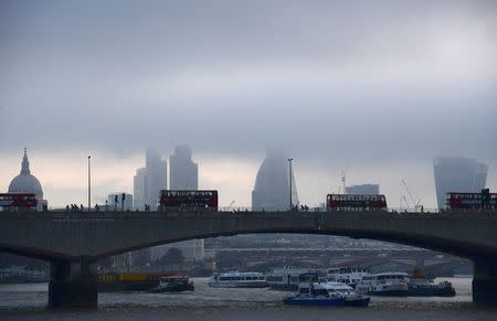 FILE PHOTO - City workers cross the River Thames with the City of London financial district seen behind in London, in Britain October 27, 2016. REUTERS/Toby Melville/File Photo