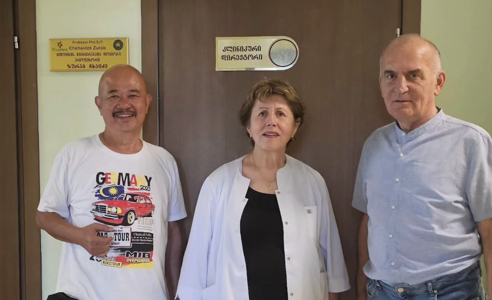 An asian man with two caucasian doctors in a Georgia clinic.